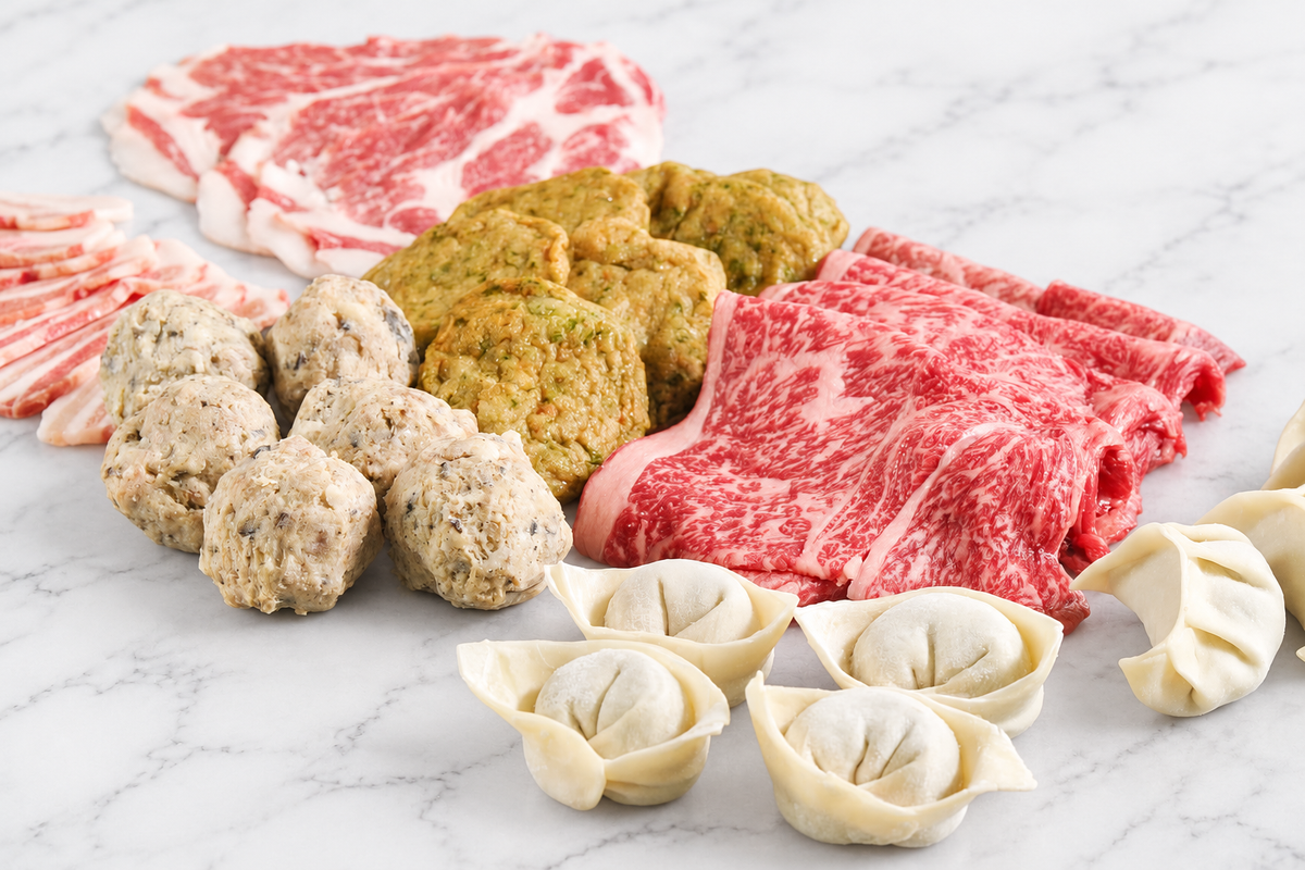 FAV Premium Hot Pot Set on white marble, alternate view with Wagyu, pork, meatballs, fish cakes and wontons