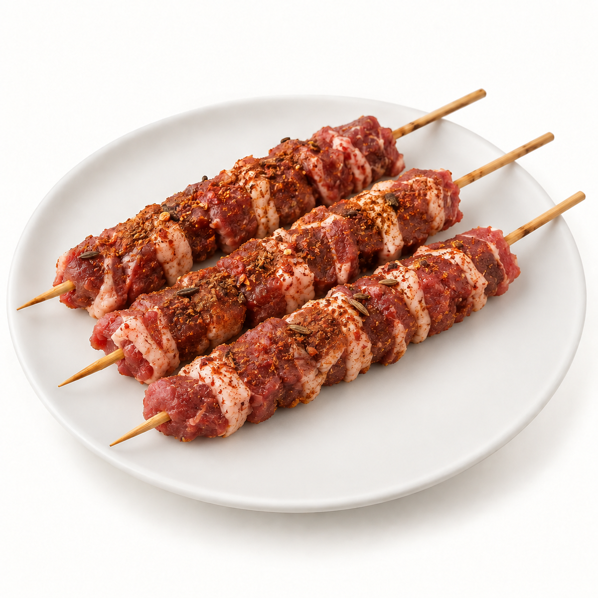 Three Sichuan-spiced cumin lamb skewers on a white plate; illustrative photo